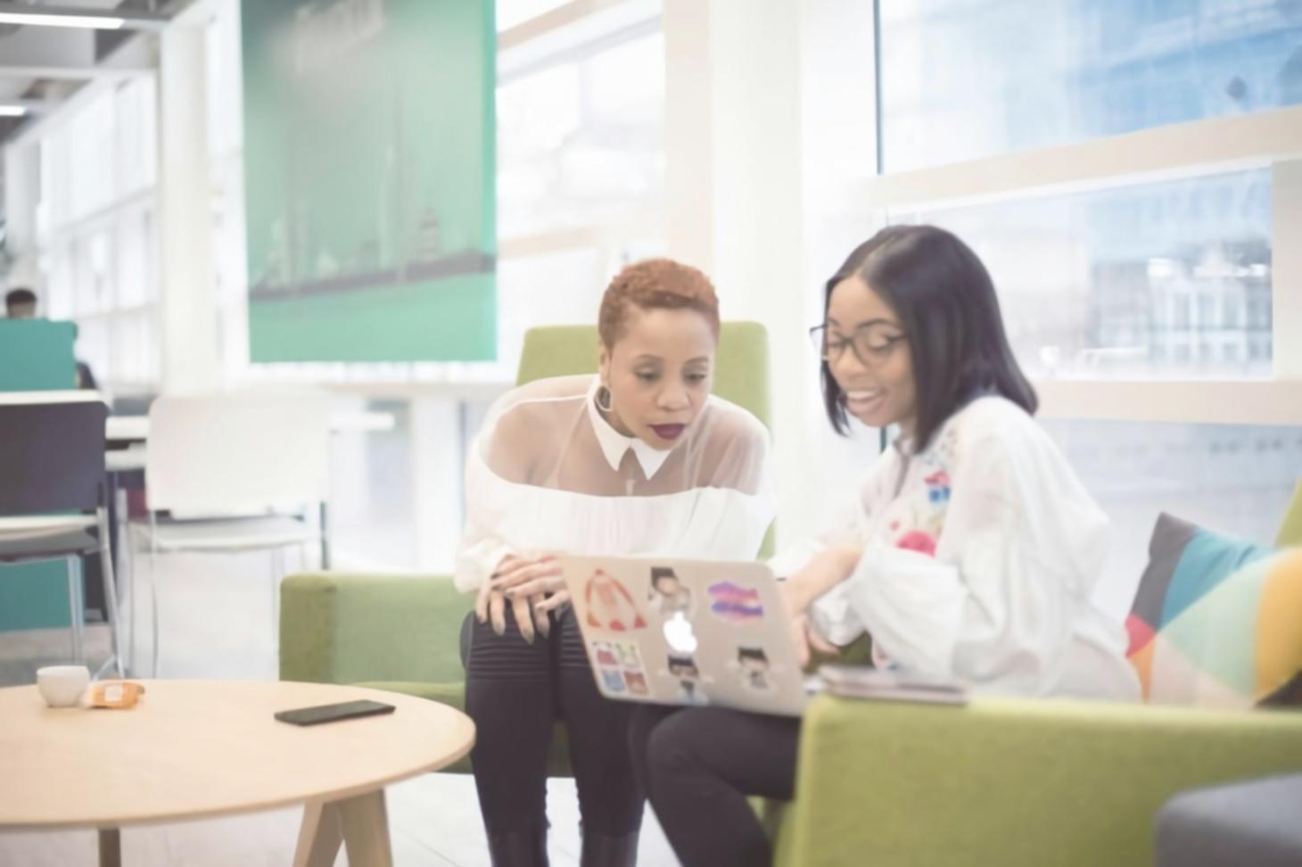 Team collaboration session with laptops and financial documents spread across table
